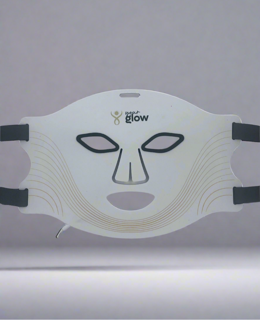 White LED face mask with black straps on a gray background