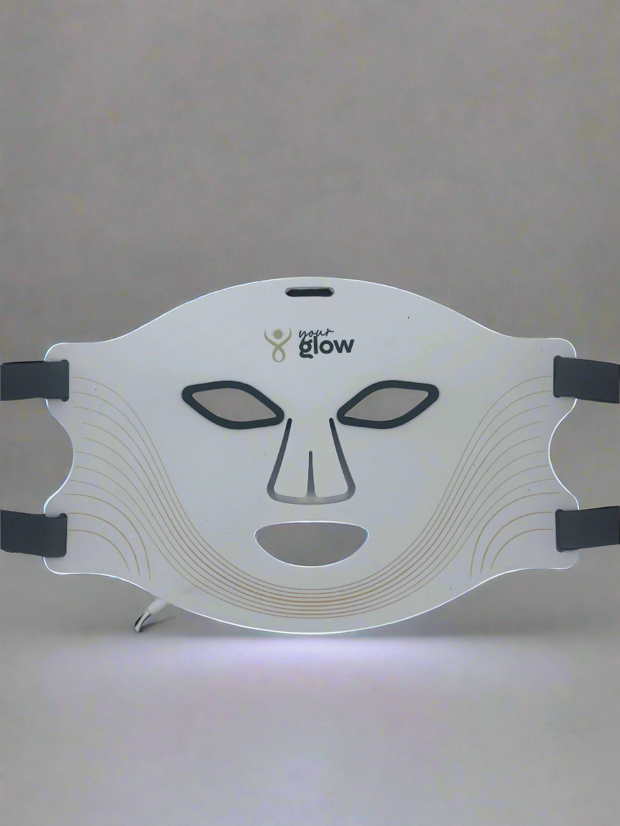 White LED face mask with black straps on a gray background
