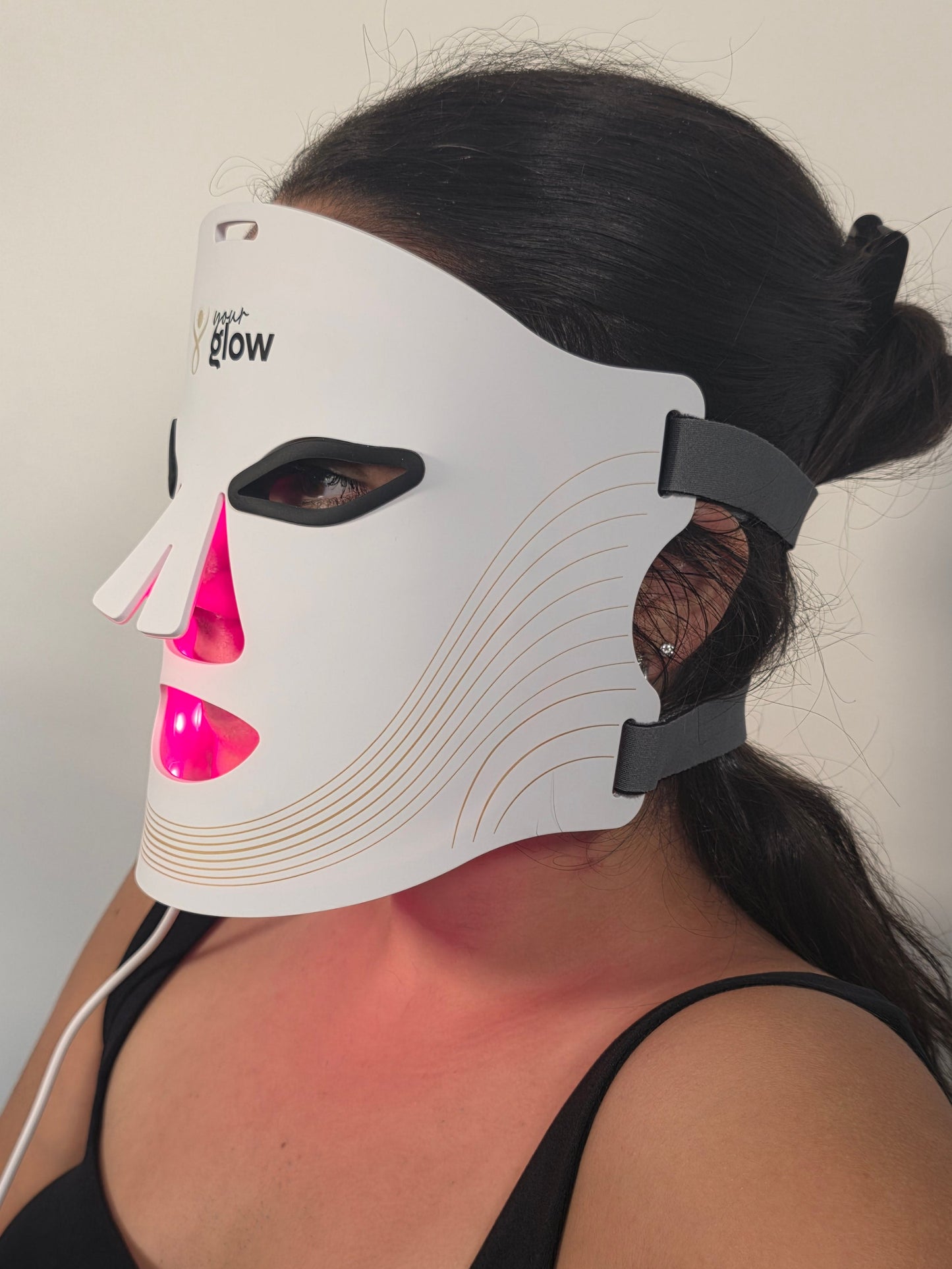 Person wearing a white LED face mask with Red light therapy on a plain background